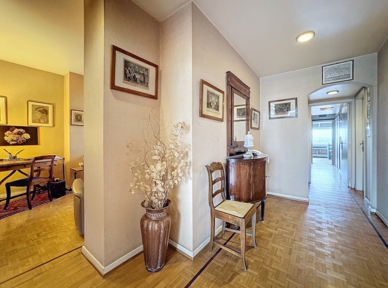 Couloir cozy avec décor, éclairage doux, meubles en bois et vue sur salle à manger chaleureuse.