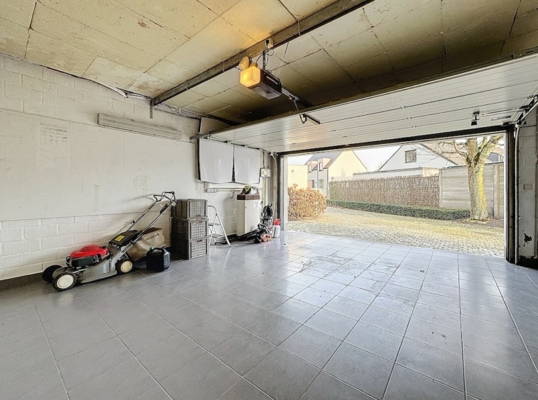 Garage lumineux, bien organisé, avec espace de rangement et vue sur quartier résidentiel verdoyant.