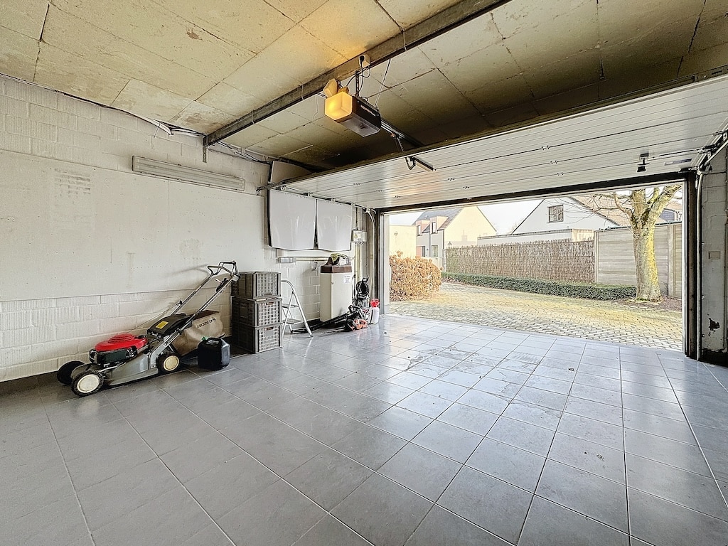 Garage lumineux, bien organisé, avec espace de rangement et vue sur quartier résidentiel verdoyant.