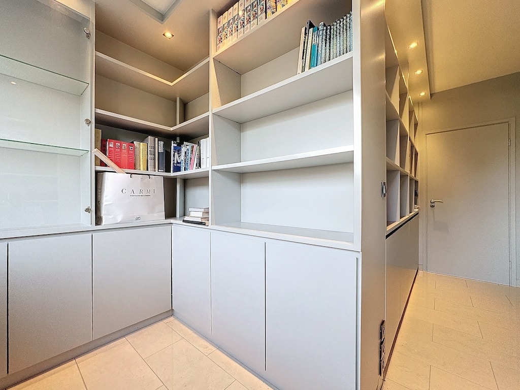 Espace de rangement moderne et minimaliste avec étagères lumineuses, éclairage subtil et ambiance organisée.
