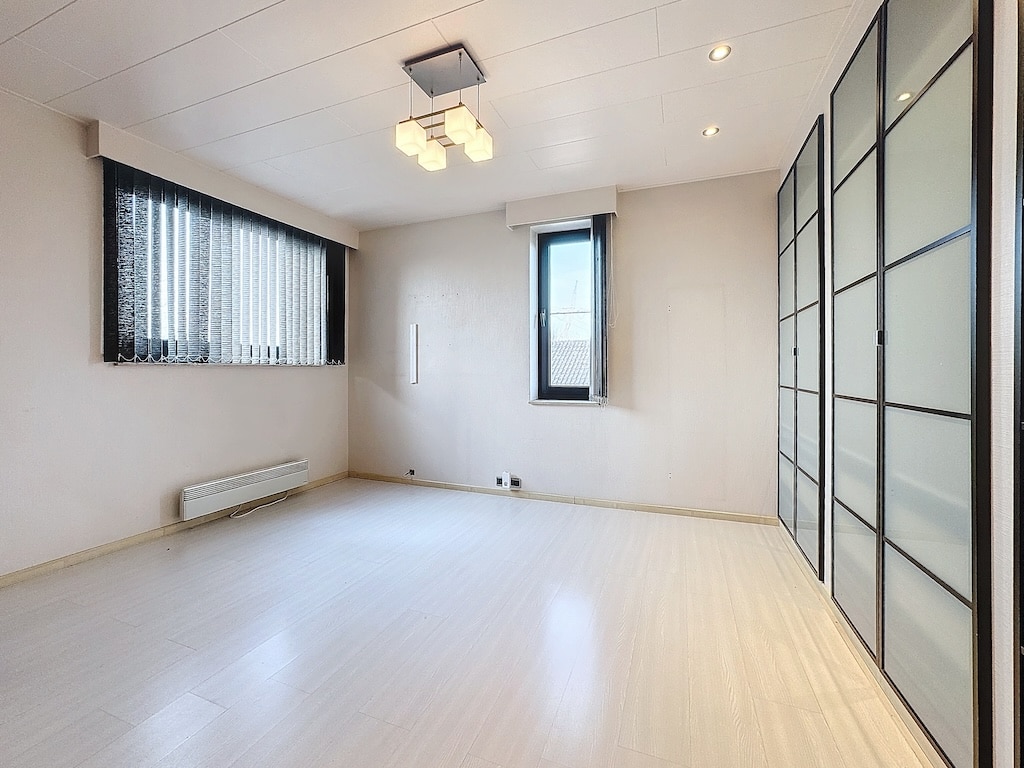 Intérieur minimaliste lumineux avec fenêtres, éclairage moderne et rangement discret.