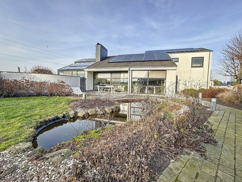 Maison moderne avec jardin Paysage, terrasse ensoleillée et vue panoramique naturelle.