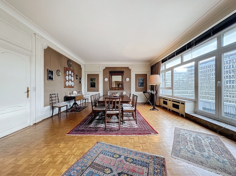 Salle à manger élégante avec mobilier classique, lumière naturelle et décoration raffinée.