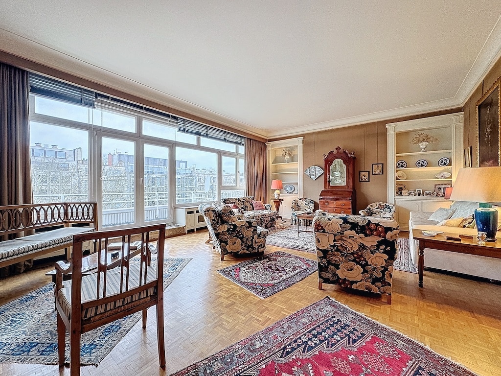 Salon chaleureux avec lumière naturelle, mobilier traditionnel, tapis coloré et décorations élégantes.