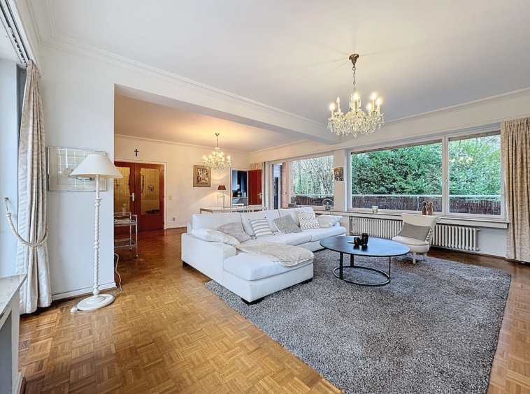 Salon moderne et accueillant avec canapé blanc, lumière naturelle et décoration élégante.