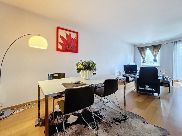 Salon contemporain avec mobilier élégant, art floral coloré, éclairage chaud et ambiance accueillante.