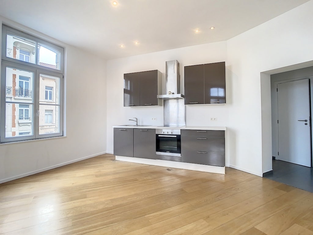 Cuisine contemporaine lumineuse avec grandes fenêtres, rangements élégants, espace convivial et design épuré.
