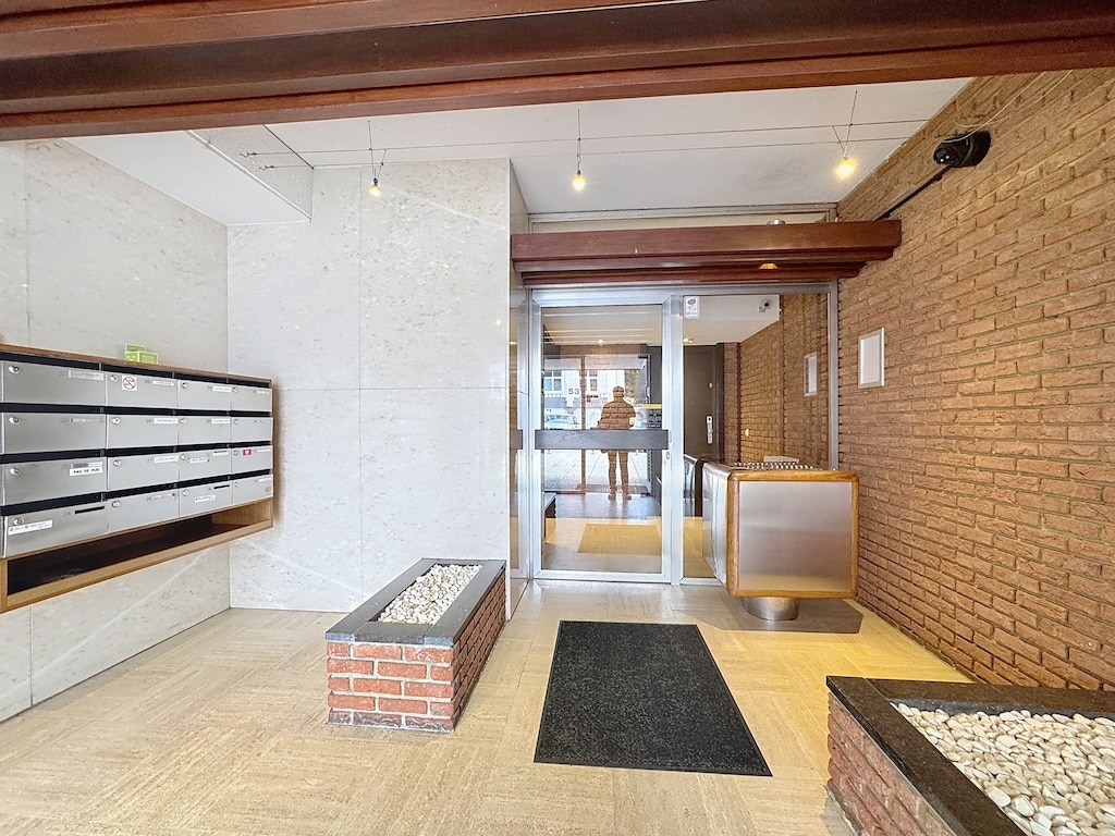Entrée moderne dimmeuble avec boîte aux lettres élégante et espace de réception chaleureuse.