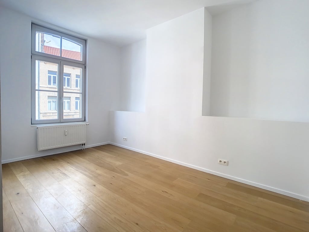 Espace minimaliste blanc lumineux avec grande fenêtre, sol en bois clair, ambiance sereine et moderne.