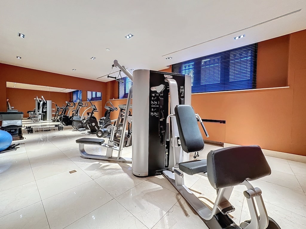 Salle de sport moderne lumineuse avec équipements multifonctions et grande luminosité naturelle