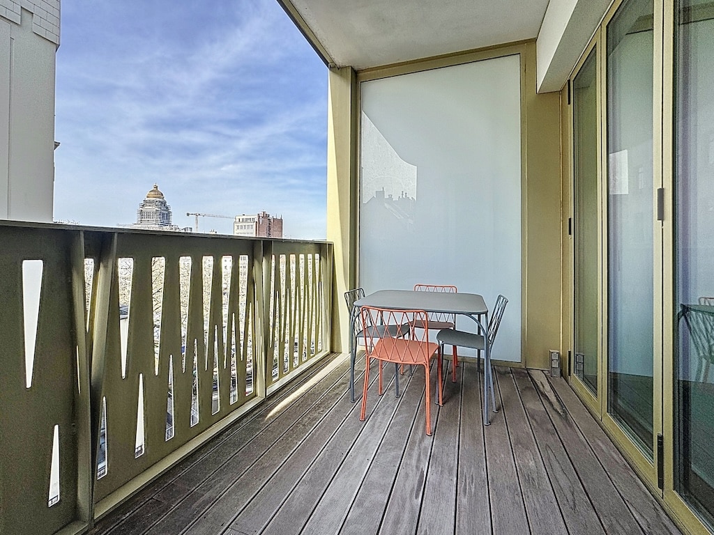 Balcon urbain avec vue panoramique, mobilier élégant et espace détente au cœur de la ville.