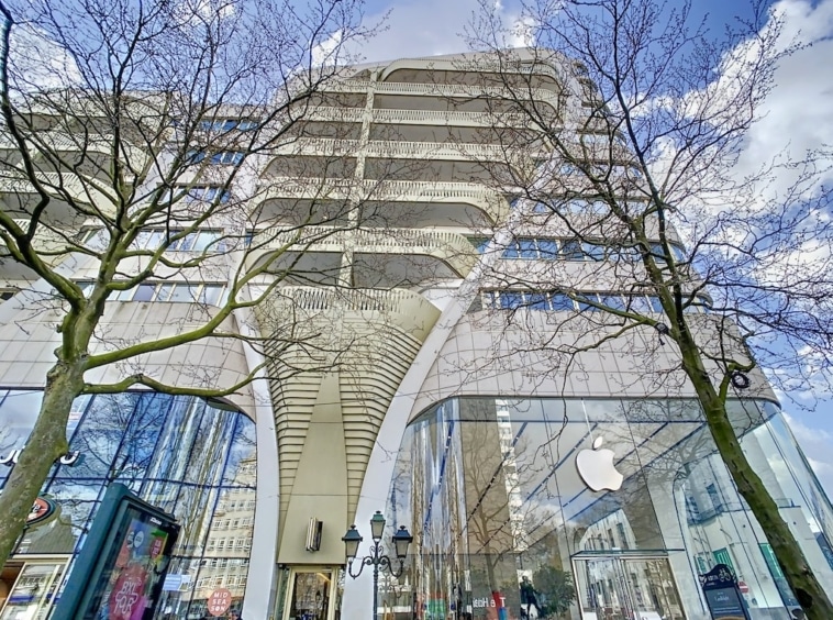Boutique Apple moderne avec architecture fluide, façade en verre et environnement urbain harmonieux.
