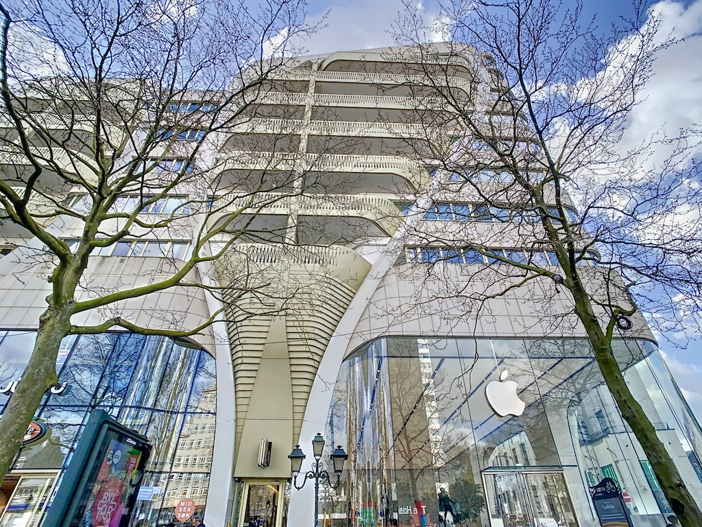 Boutique Apple moderne avec architecture fluide, façade en verre et environnement urbain harmonieux.