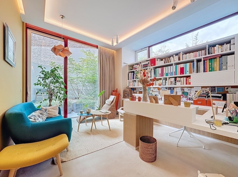 Bureau moderne et cosy avec vue verdoyante, lumière naturelle, mobilier épuré et espace inspirant.