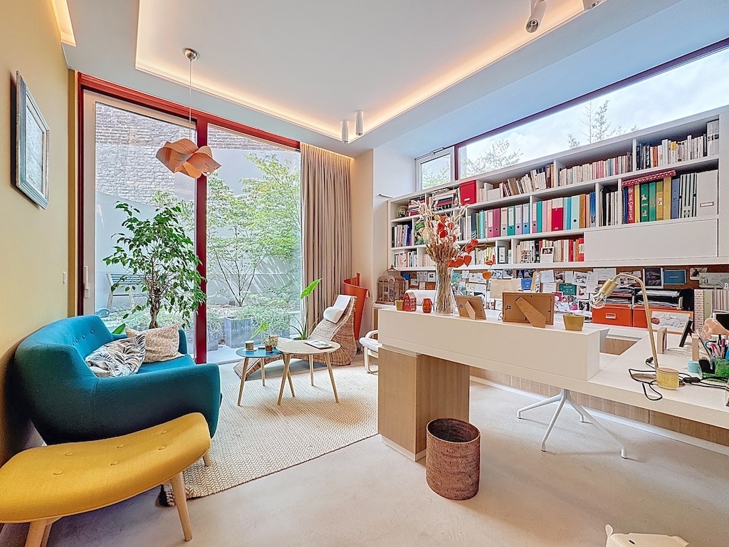 Bureau moderne et cosy avec vue verdoyante, lumière naturelle, mobilier épuré et espace inspirant.