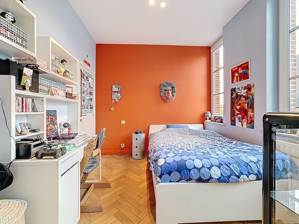 Chambre moderne colorée avec murs vifs, mobilier épuré et décoration artistique lumineuse.