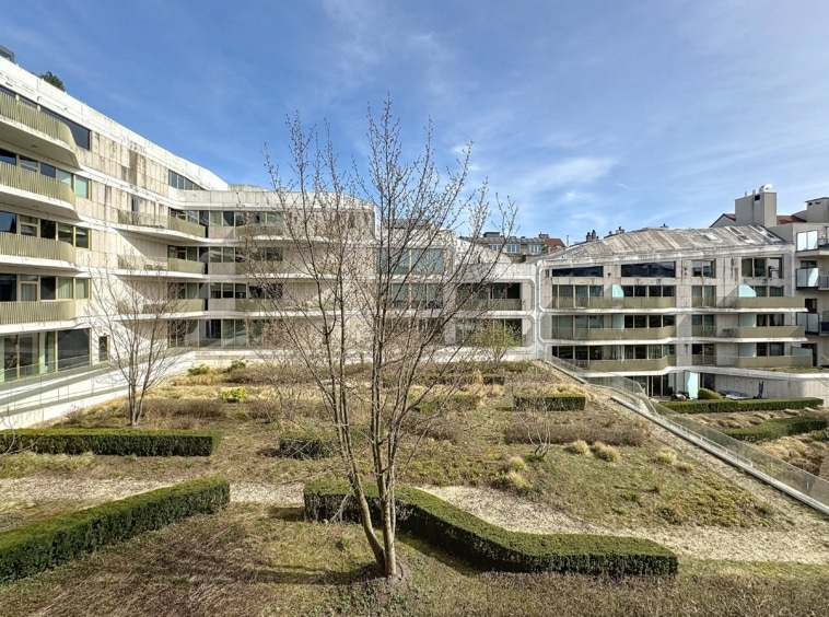 Complexe résidentiel moderne avec architecture minimaliste, espaces verts, et ambiance paisible.