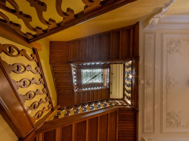 Escalier en colimaçon en bois poli, décoration élégante, ambiance chaleureuse et raffinée.