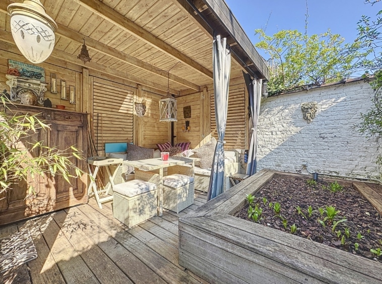 Coin extérieur cosy en bois, plantes vertes et ambiance paisible pour se détendre.