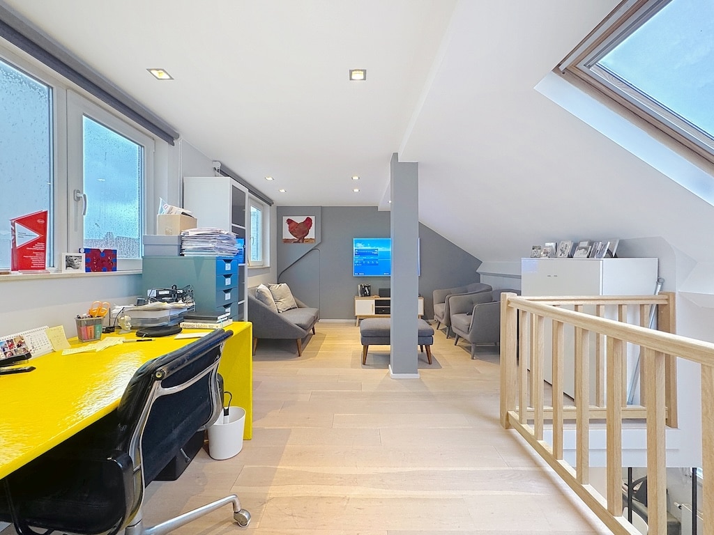 Loft moderne lumineux avec espace de travail coloré et coin détente cosy, style contemporain et épuré.