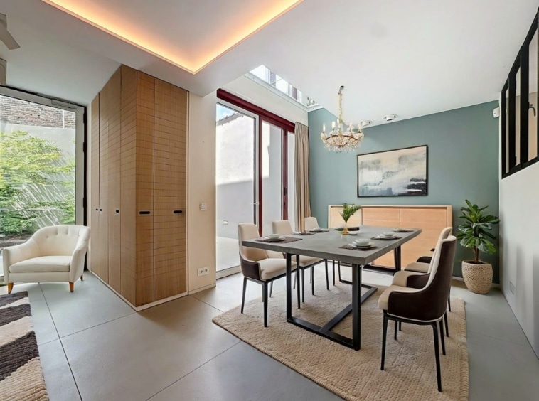 Salle à manger moderne lumineuse avec mobilier élégant, vue verte et décoration chaleureuse.