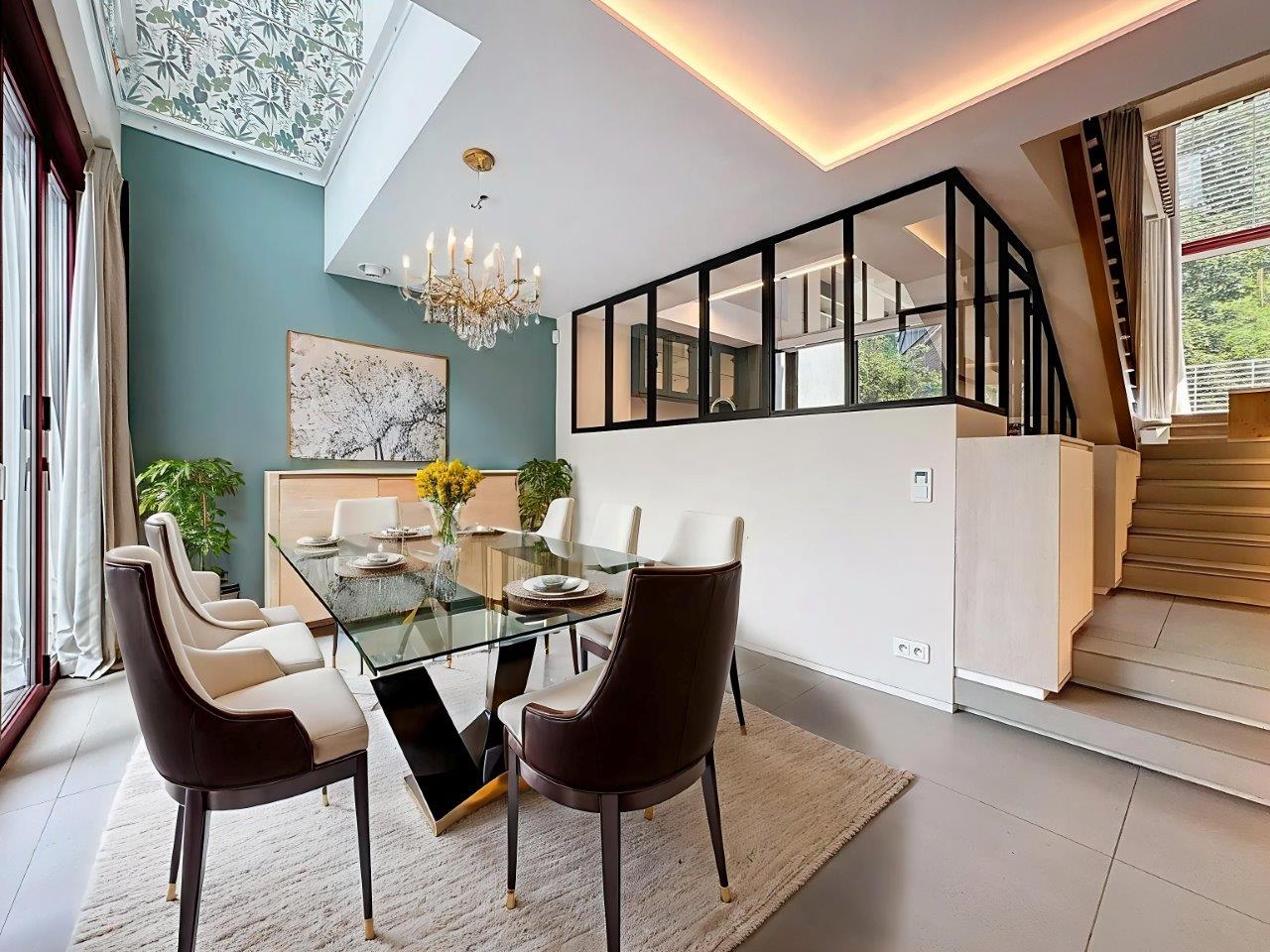 Salle à manger moderne avec table en verre, chaises élégantes, éclairage chic et ambiance lumineuse.