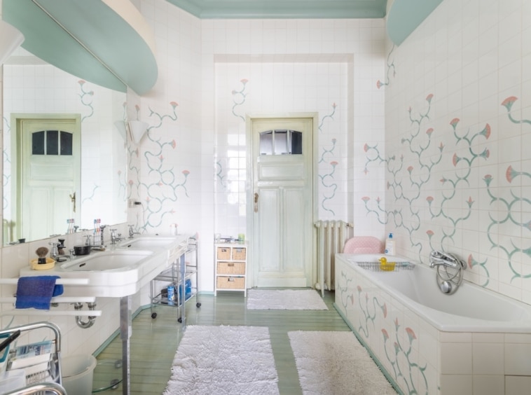 Salle de bain élégante avec double lavabo, décoration florale, baignoire et ambiance naturelle apaisante.