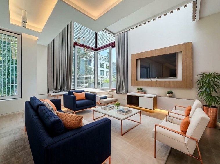 Salon contemporain lumineux avec canapé bleu, lumière naturelle, décoration minimaliste et touche végétale.