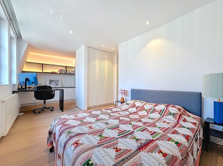 Chambre moderne lumineuse avec lit coloré, bureau organisé et décoration épurée.
