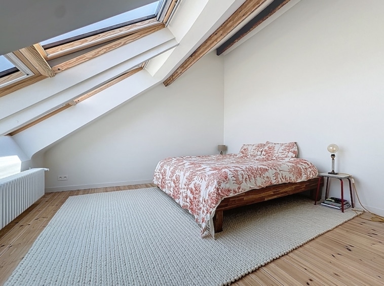 Chambre cosy et lumineuse avec lits, bois clair, accents métalliques et ambiance relaxante.
