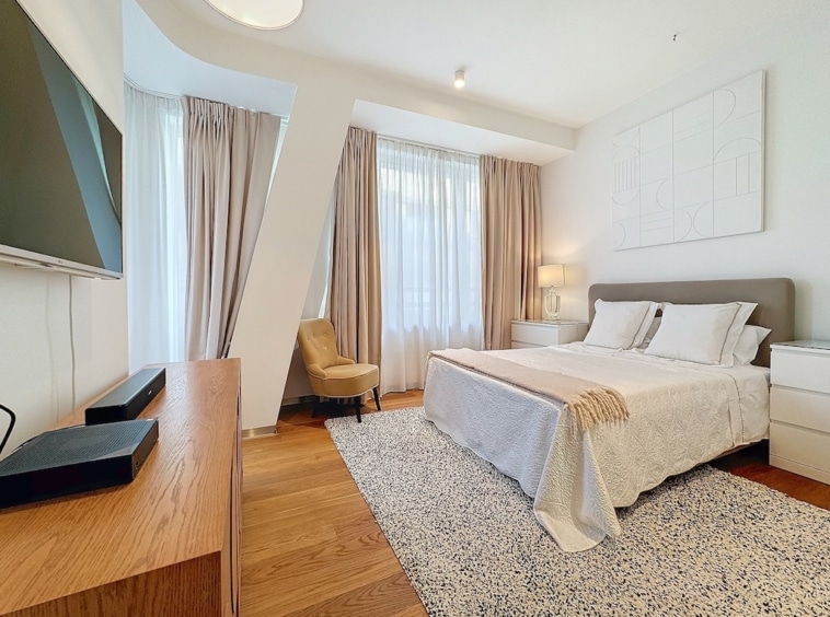 Chambre moderne lumineuse avec grand lit, décoration épurée, mobilier élégant et vue dégagée.