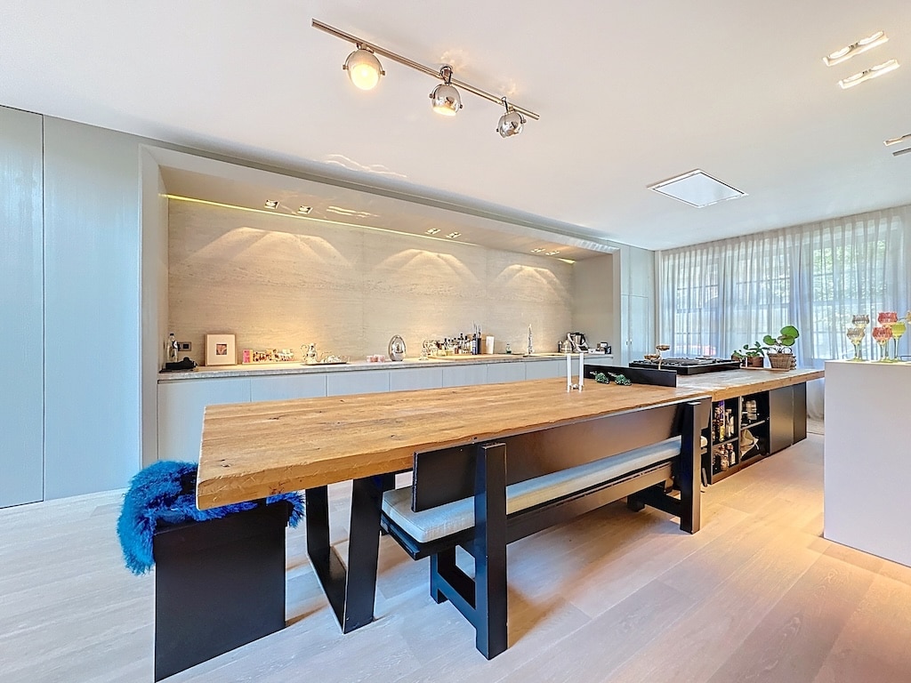 Cuisine moderne avec table en bois naturel, éclairage doux et décoration élégante.