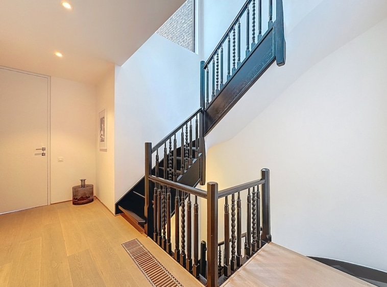 Escalier en bois foncé, design épuré, luminosité naturelle, ambiance moderne et chaleureuse.
