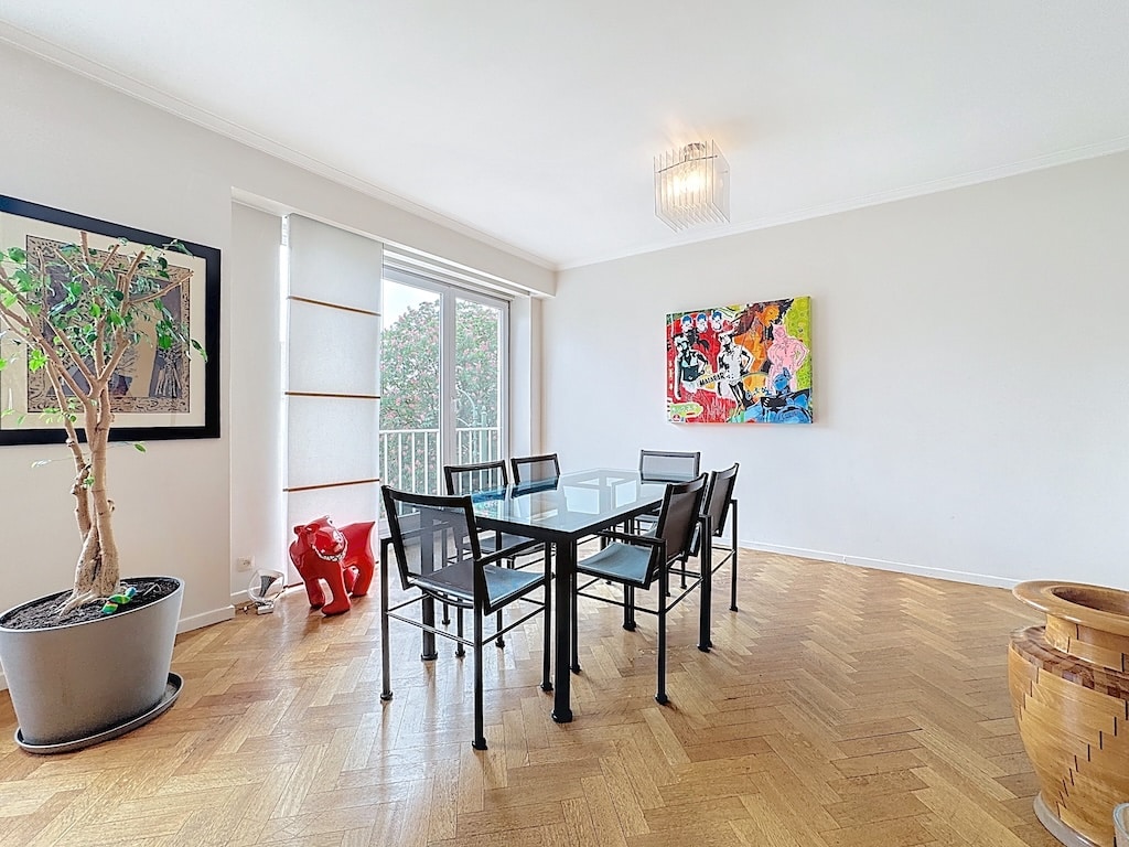 Salle à manger contemporaine avec table en verre, art coloré et sculptures rouges élégantes