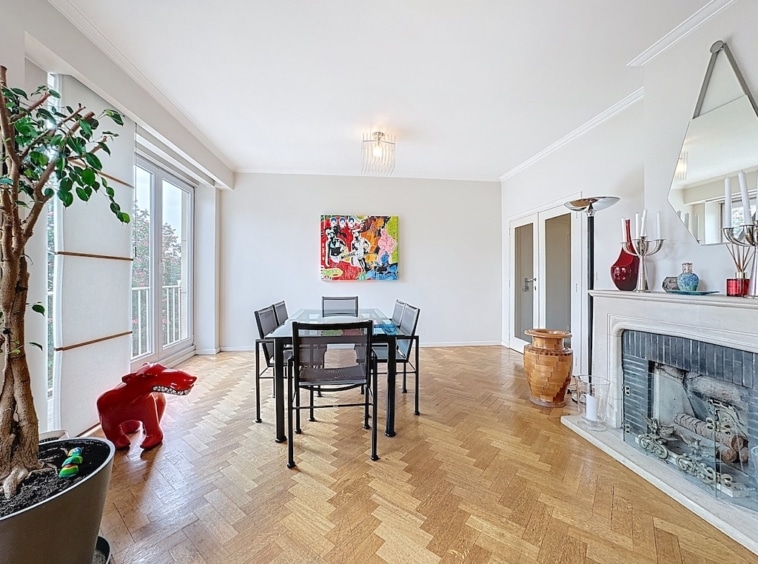 Salle à manger moderne lumineuse avec art coloré, mobilier épuré et décoration raffinée.
