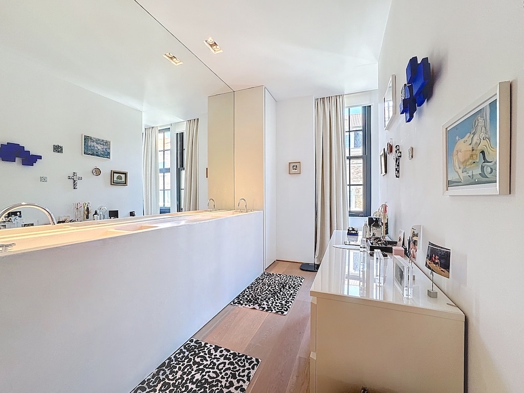 Salle de bain moderne avec miroir, lumière naturelle, design élégant, décoration raffinée, ambiance apaisante.