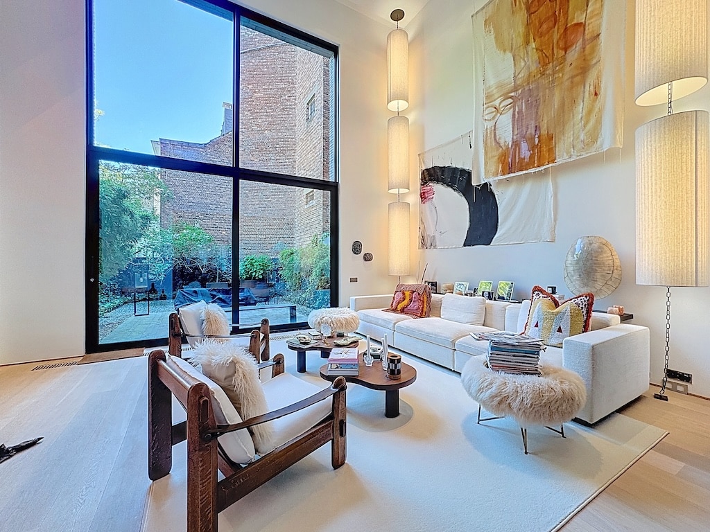 Salon contemporain lumineux avec vue panoramique, mobilier élégant, décoration artistique et ambiance chaleureuse.