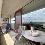 Balcon moderne avec mobilier confortable, vue urbaine et ambiance élégante.