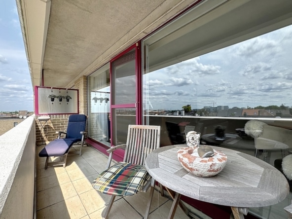 Balcon moderne avec mobilier confortable, vue urbaine et ambiance élégante.