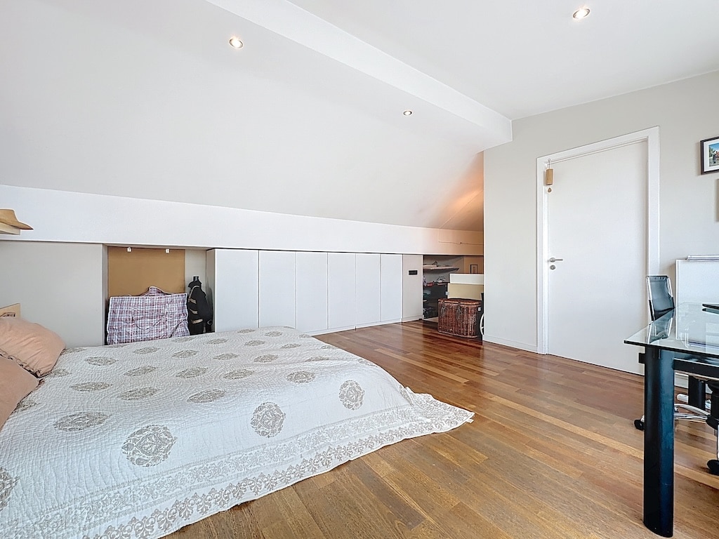 Chambre mansardée moderne, lumineuse, espace de travail, rangement intégré, ambiance cosy et élégante.