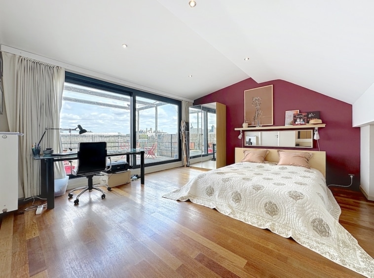 Chambre moderne avec vue panoramique, mobilier épuré, parquet en bois et décoration chaleureuse.