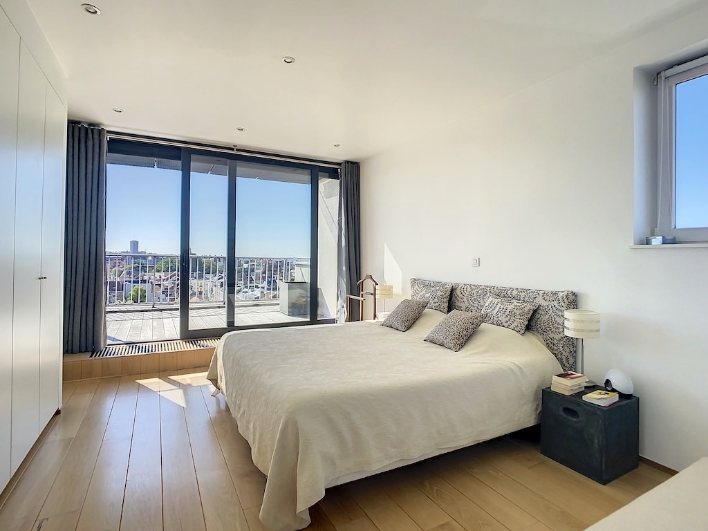 Chambre moderne avec vue lumineuse, mobilier minimaliste, ambiance sereine et élégante.