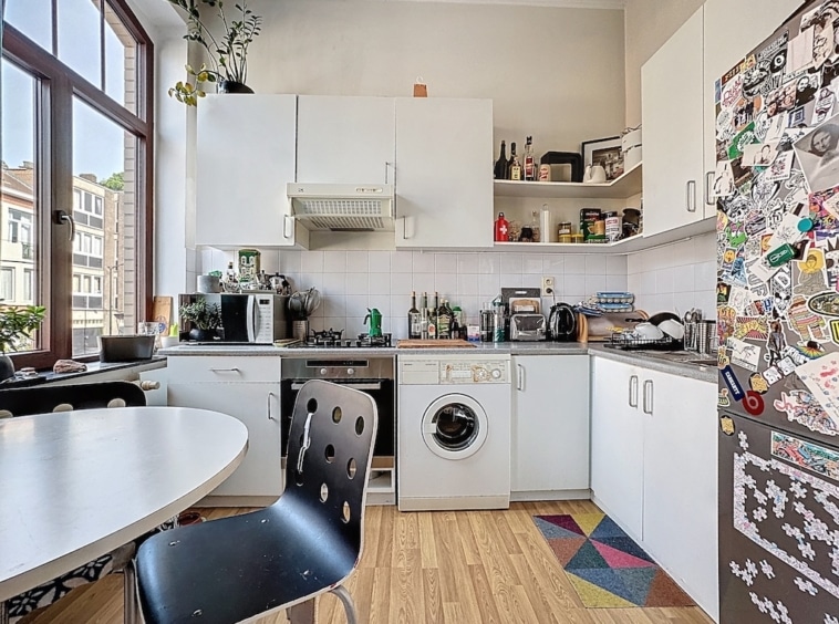 Cuisine lumineuse, moderne, pratique avec mobilier blanc, plantes, appliances, et décoration personnalisée.