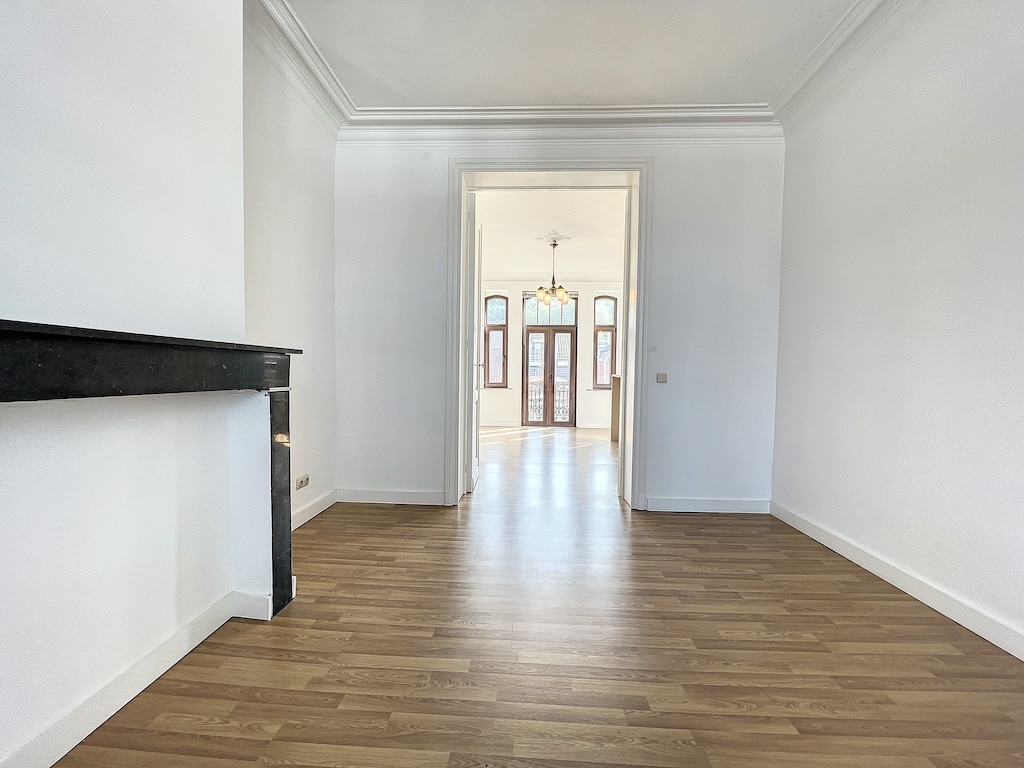 Espace lumineux et moderne avec cheminée élégante, portes en verre et décoration minimaliste.