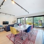 Salon et salle à manger modernes lumineux avec mobilier coloré et décoration artistique.