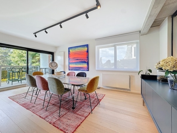 Salle à manger élégante lumineuse avec mobilier coloré, art abstrait, vue extérieure et décoration moderne.