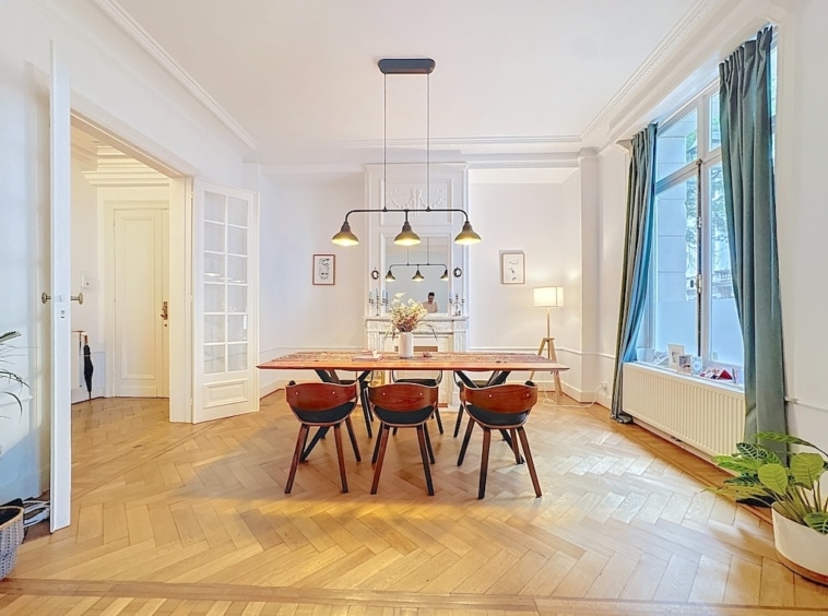Salle à manger moderne avec mobilier chic, lumière naturelle, plantes, et décoration élégante.