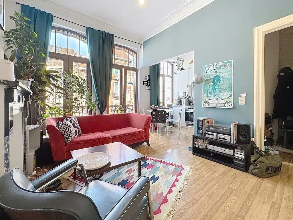 Heldere en kleurrijke woonkamer met rode bank en eclectische inrichting Zitkamer - Appartement - 1 slaapkamer - Dudenpark - Bos