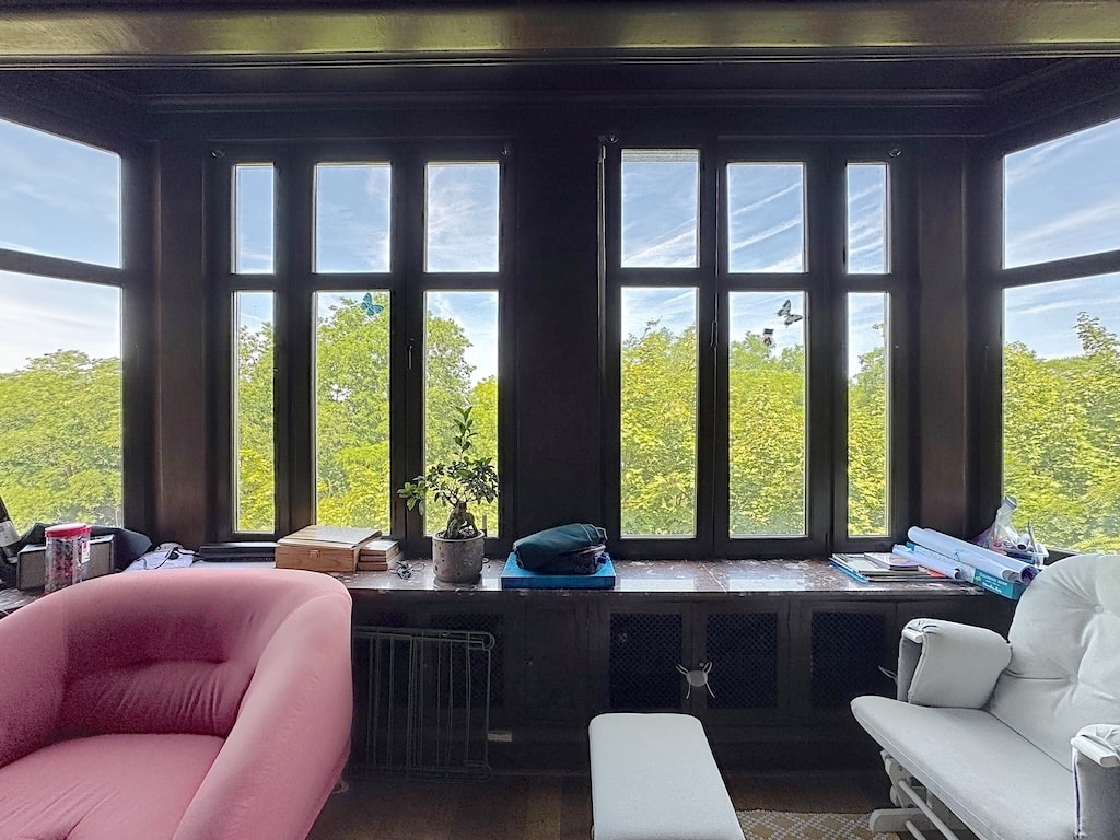 Salon lumineux avec vue sur la nature, mobilier moderne, ambiance cosy et apaisante.