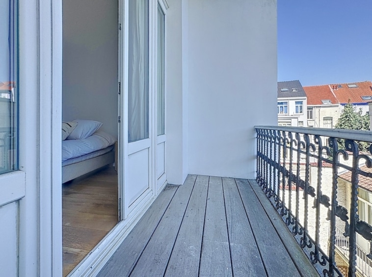Balcon sophistiqué avec vue urbaine, plancher en bois et intérieur lumineux.